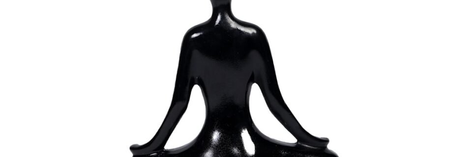 a black statue of a person sitting in a yoga position